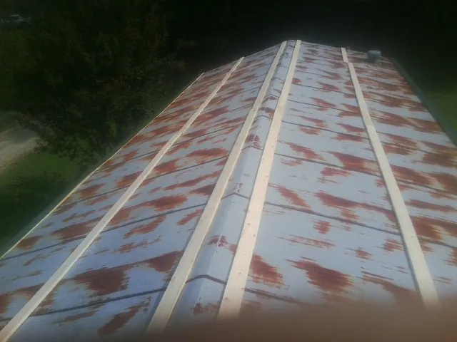 Rusted metal roof panels with new wood purlins before replacement — Storm Damage Roof Repair in Cedarhurst by Roofing Brothers